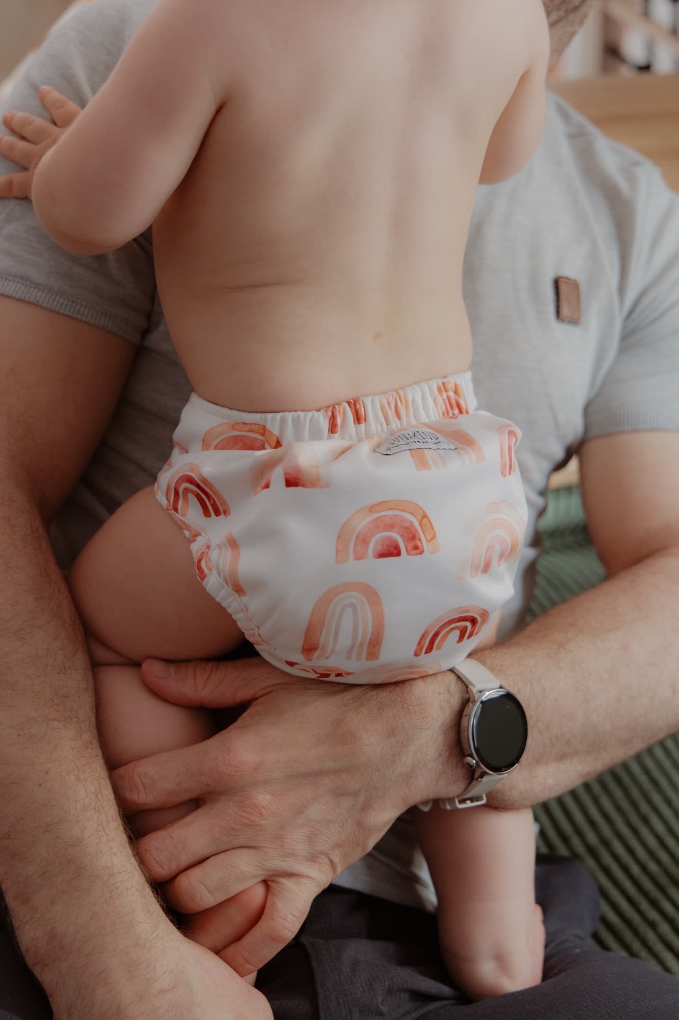 Baby in a cloth diaper held in arms, close-up