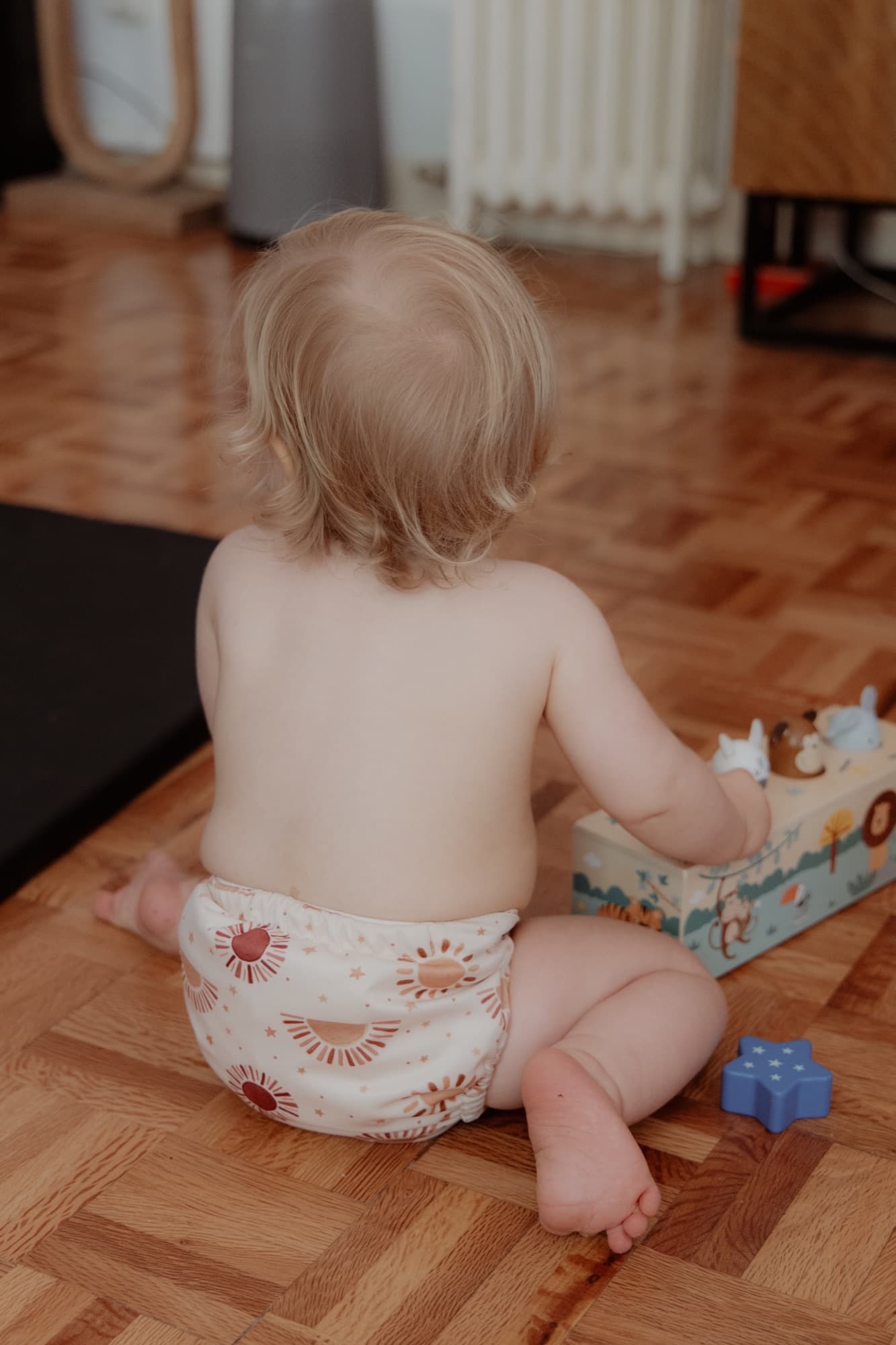 Toddler in a cloth diaper, sitting and playing