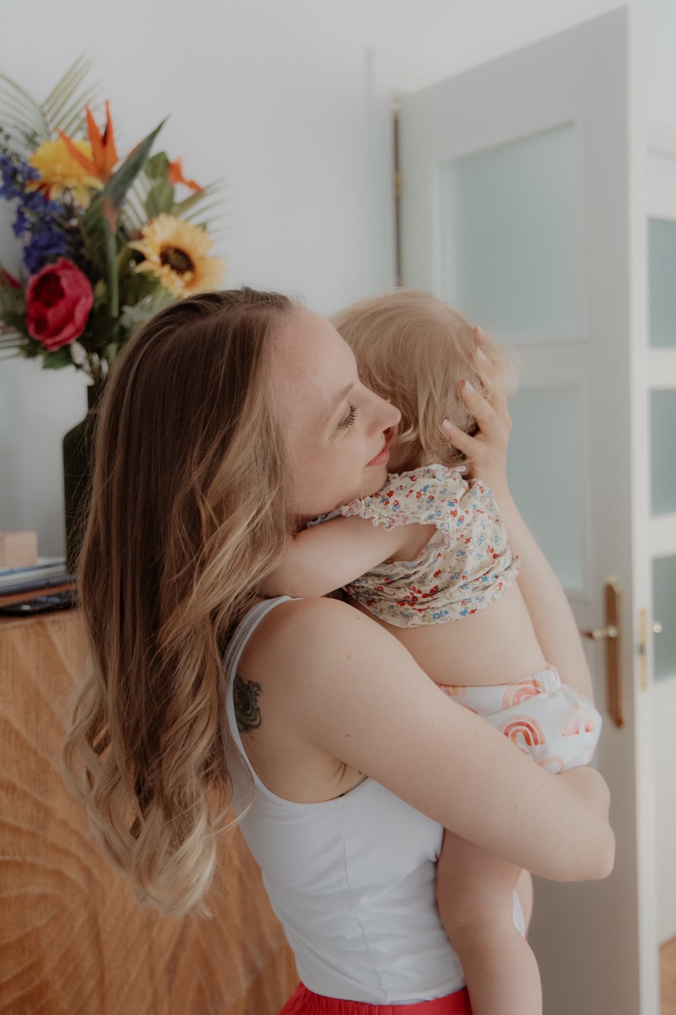 Lara holding her child, side view, warm light
